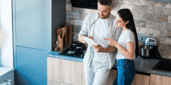 couple holding a tablet in their kitchen